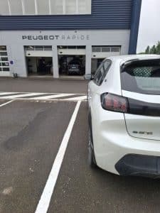 eugeot e-208 blanche déposée chez Peugeot pour entretien dans le cadre du service de conciergerie automobile KirriGo à Rennes