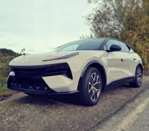Lotus Eletre blanche sur route de campagne, SUV électrique de luxe au design sportif.
